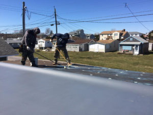 The application of the adhesive to the fiberboard and to the TPO roof membrane