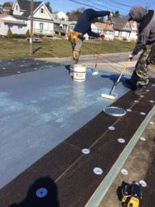 The application of the adhesive to the fiberboard and to the TPO roof membrane